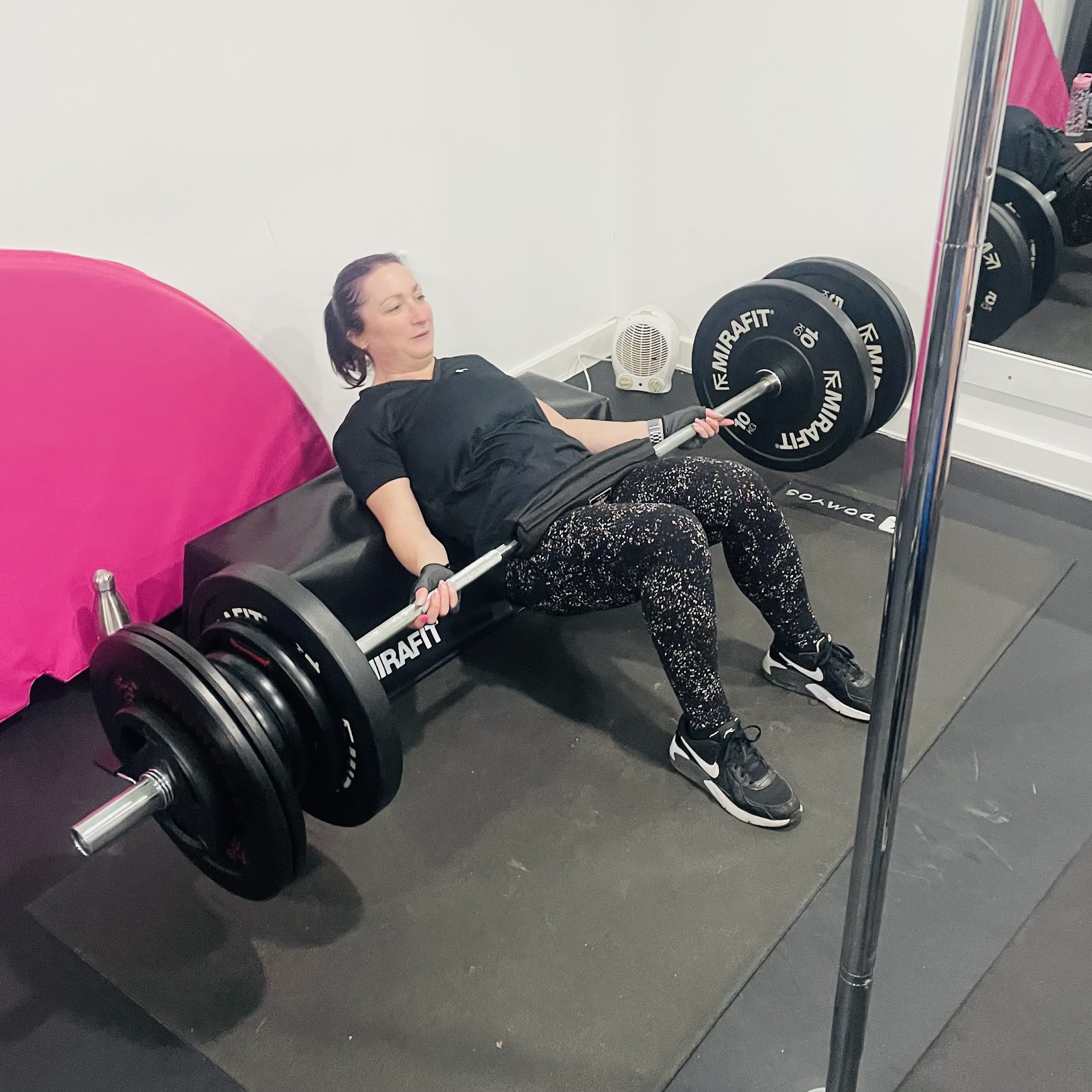 A member doing barbell hip thrusts
